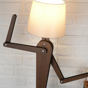 Handmade wooden floor lamp showcasing unique design with adjustable arm and soft fabric shade, ideal for home décor.